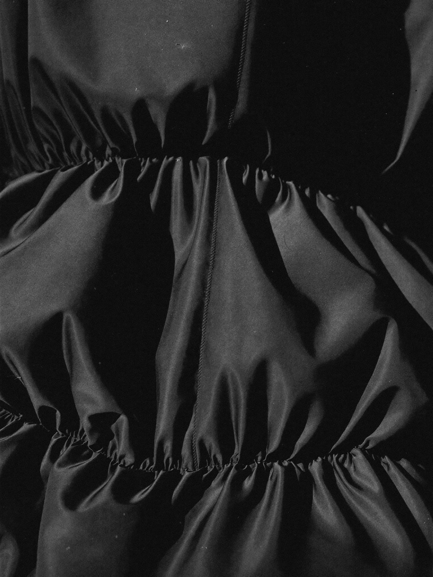 Close study of black fabric folds and texture in monochrome.
